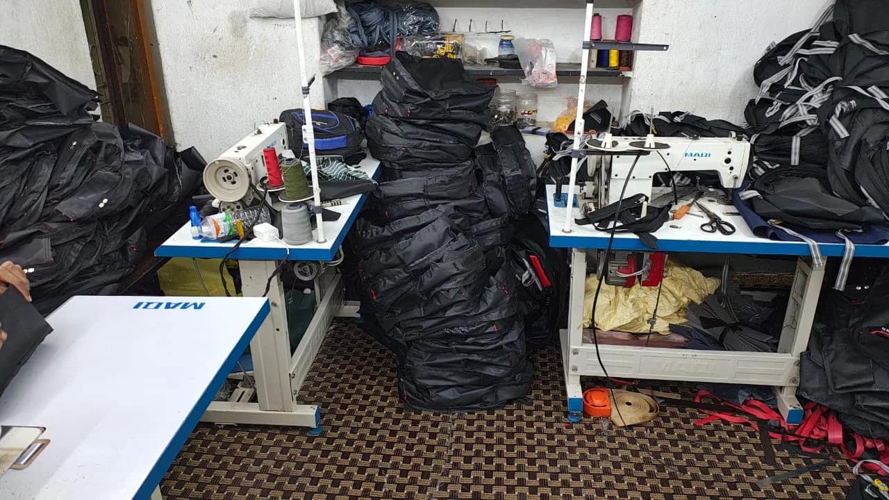 Sewing machines and finished bags on the ABM Bags workshop floor in Hyderabad