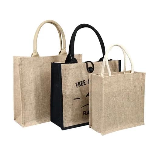 Three jute tote bags in different sizes with rope and webbing handles, one printed with a design